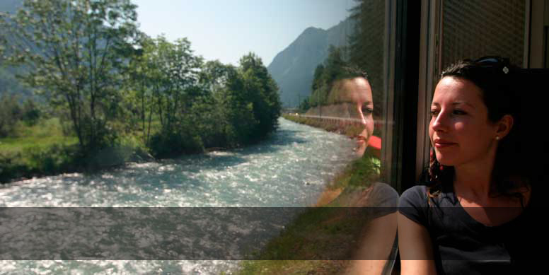 Junge Frau betrachtet die Landschaft aus dem Zugfenster